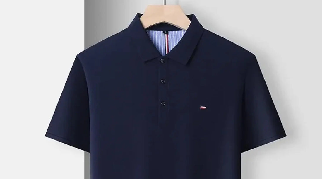 A dark blue polo shirt with short sleeves displayed against a plain, light-colored background. 