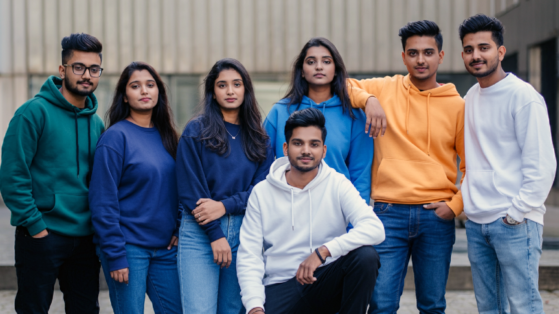 A group of young women and men, dressed casually in various coloured hoodies, sweatshirts, and Tees from Entimessi. 