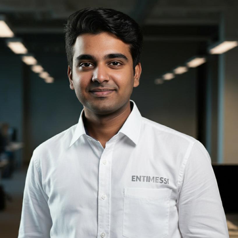 A young man, dressed in a tailored white shirt, stands confidently in a corporate office